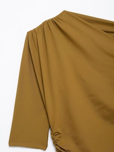 Close-up of mustard brown top featuring elegant side ruching and pleated shoulder texture
