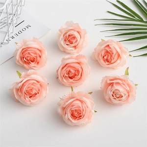 Seven artificial champagne pink silk rose heads arranged with a palm leaf and grid basket