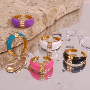 Detailed view of colorful enamel rings with gold plating and sparkling crystals