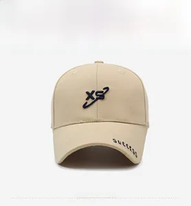 Broderie détaillée du logo XS et du texte SUCCESS sur la visière d'une casquette beige
