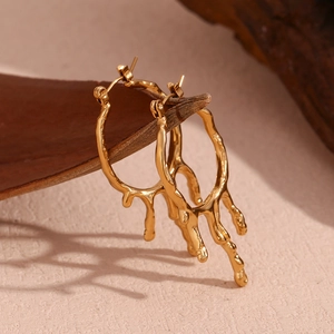 Detailansicht der goldenen Lava-Ohrringe mit flüssigem strukturiertem Metalldesign