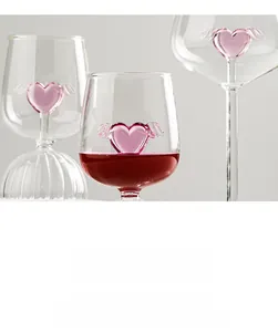 Close-up of glass wine goblet with a 3D pink winged heart and elegant liquid display