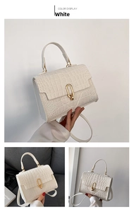 Detail view of white crocodile pattern shoulder bag with a gold metal ring buckle