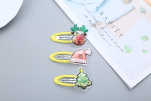 Close-up of yellow Christmas hair clips with reindeer, Santa hat and tree decorations