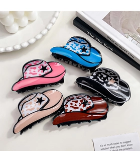 Dettaglio di cinque mollette per capelli a cappello da cowboy con stelle e stampe