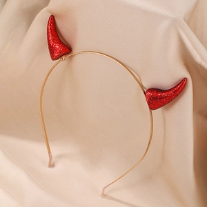 Gros plan des cornes de diable rouges à paillettes sur un serre-tête doré pour Halloween