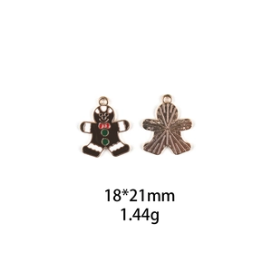Detailed view of gingerbread man alloy charm with brown oil drip and gold metal back