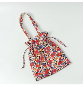 Detail of floral canvas tote bag with drawstring closure and dense flower patterns