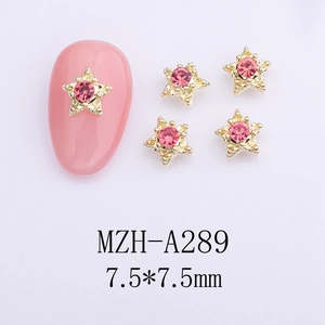 Macro shot of 7.5mm star-shaped nail gems with pink rhinestones on gold metal frames