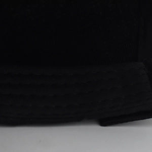 Detailed close-up of reinforced multi-row stitching on black canvas baseball cap brim