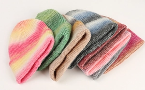 Macro detail of ribbed knit texture on colorful gradient tie-dye winter beanies