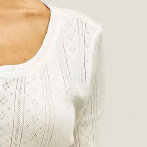 Haut de détente blanc en maille pointelle à manches longues avec motifs ajourés