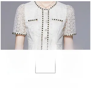 Detail of white lace dress with floral textures, pearl buttons and woven trim