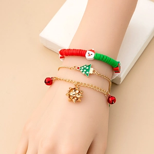 Detailed view of three Christmas bracelets with Santa and bell charms on a model's wrist