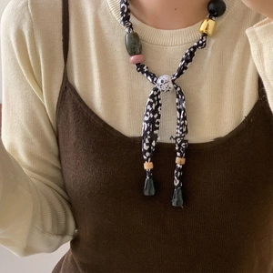 Close-up of leopard print fabric cord necklace with mixed beads on a female model