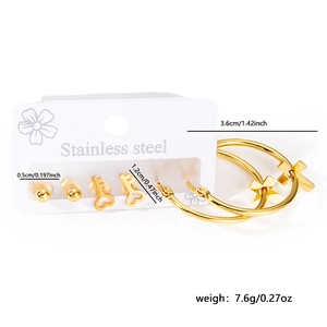 Detailed macro view of a 3-pair gold stainless steel earring set with heart and cross motifs