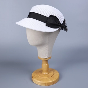 Dettaglio della trama intrecciata e del fiocco in nastro nero sul cappello di paglia