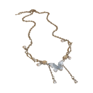 Collana a farfalla in argento con cianite blu e perle su sfondo bianco