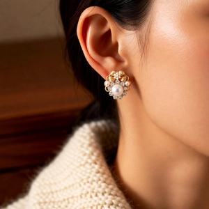 Macro shot of vintage pearl flower earrings with crystals on gold-plated metal studs