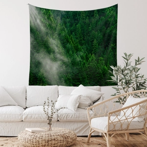 Detailed view of bohemian forest tapestry hanging on wall above a white sofa