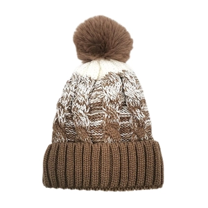 Dettaglio del berretto in maglia tie-dye marrone e bianco con pompon soffice e bordo a coste
