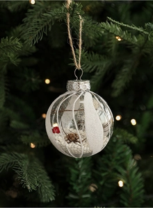 Detail of 8cm clear Christmas ball filled with pine cones and berries on a tree