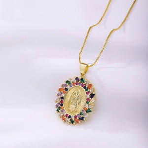 Détail du pendentif Vierge Marie en or avec zircons colorés sur fond de satin blanc