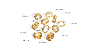 Detail view of 10-piece gold geometric rings showing varied widths and intricate textures