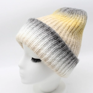 Detail of the chunky knit texture and yellow to grey gradient on the warm winter beanie