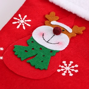 Macro detail of red felt Christmas stocking featuring reindeer and snowflake embroidery