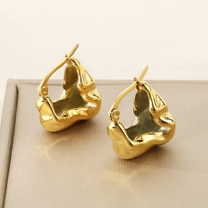 Detail view of high-polish 18K gold irregular molten liquid earrings on a display case