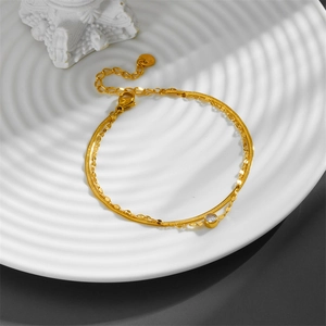 Detail of double-layer gold titanium steel bracelet with sparkling round zircon stone