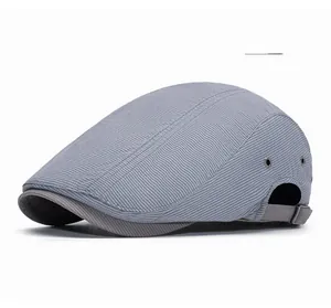 Close-up of light gray flat cap featuring side metal eyelets and adjustable rear strap