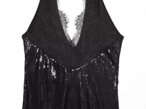 Macro view of black lace trim and shimmering sequins on a deep V-neck dress