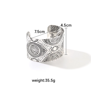 Detail shot of vintage silver-tone wide cuff bracelet with ethnic embossed patterns