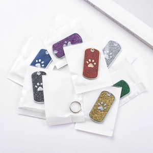 Glitter dog tags with paw print design in multiple colors and stainless steel rings
