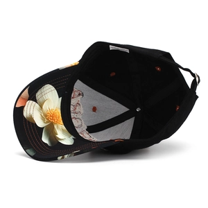 Detail view of cotton baseball cap interior with white flower print and adjustable metal buckle