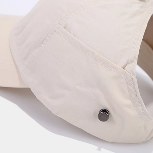 Detail view of beige baseball cap featuring premium stitching and metal rivet decoration