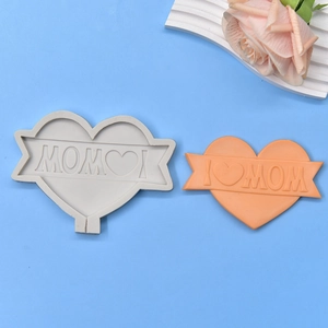 Macro shot of I ❤️ MOM heart silicone mold with bright orange handmade finished product