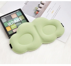 Detailed view of green 3D contoured sleeping mask, ergonomic cloud shape design for shading.