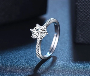 Detailed macro view of silver heart ring with six-prong set brilliant round diamond