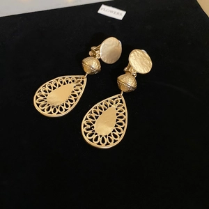 Detailed close-up of vintage gold hollow teardrop earrings with hammered texture