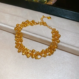 Detailed macro of 24K gold plated multi-strand bead bracelet with heart charm and lobster clasp