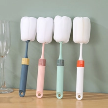 Hanging sponge bottle brushes in four colors arranged neatly on a wooden surface