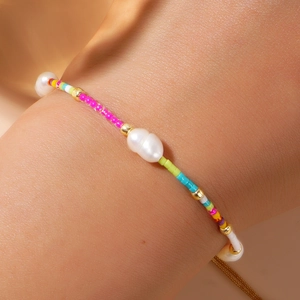 Detail of handmade rainbow beaded bracelet with natural freshwater pearls on wrist