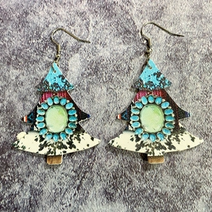 Detail of Christmas tree faux leather earrings with bohemian stone and cow patterns
