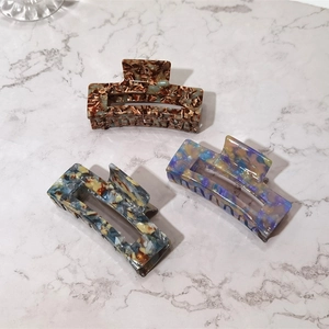 Close-up of tortoise shell and marble texture acetate square claw clips on marble