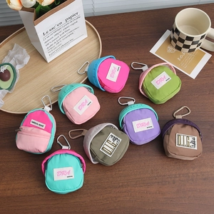 Mini backpack charms in various candy colors with carabiner on a wooden background