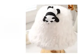 Dettaglio della finta pelliccia e del panda pupazzo sul cappello a secchiello bianco