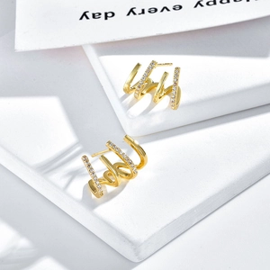 Elegant four-claw gold-plated spiral earrings with micro-set zircons on white steps